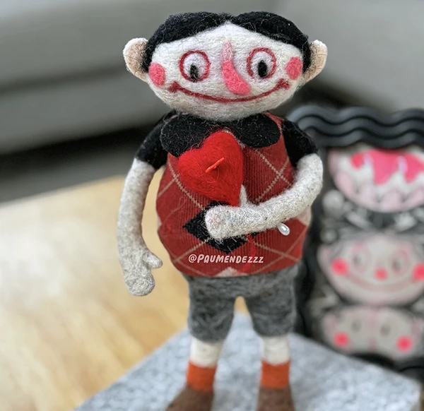 Muñeco en fieltro sosteniendo un corazon rojo