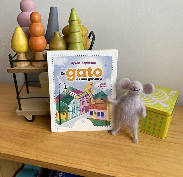 Libro ilustrado sobre una mesa junto a una figura en fieltro
